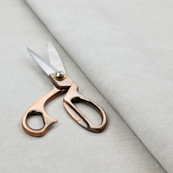 A textured, light beige or cream-coloured woven upholstery fabric.