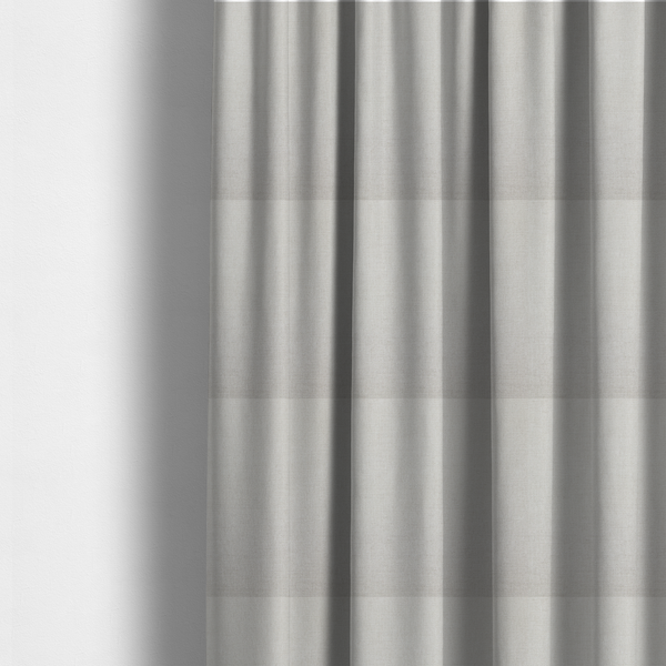 The fabric used to create these made-to-measure curtains is a textured, light beige or cream-coloured woven upholstery fabric.