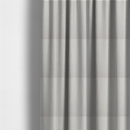 The fabric used to create these made-to-measure curtains is a textured, light beige or cream-coloured woven upholstery fabric.