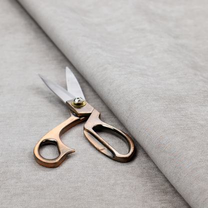 A textured, light taupe or greyish-beige woven upholstery fabric.