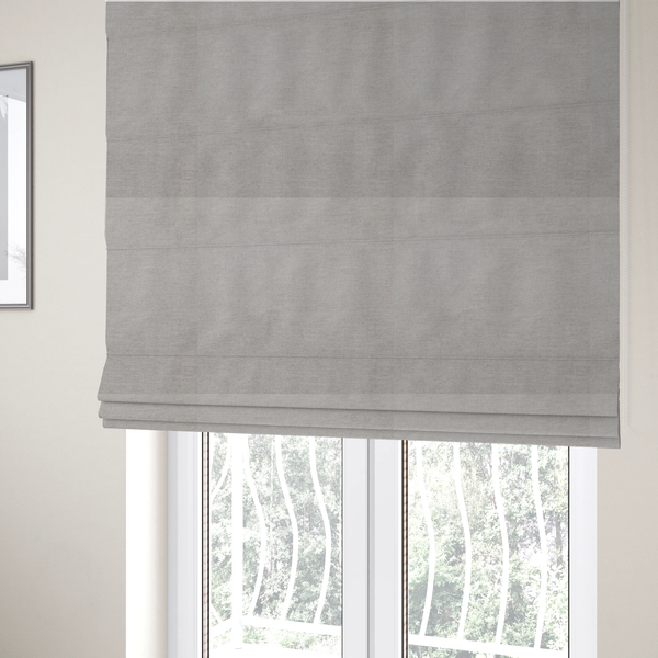 The fabric used to create these Roman blinds is a textured, light taupe or greyish-beige woven upholstery fabric.