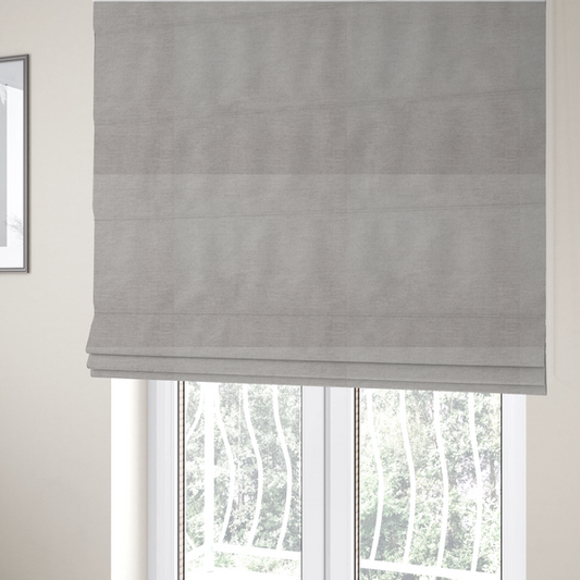 The fabric used to create these Roman blinds is a textured, light taupe or greyish-beige woven upholstery fabric.