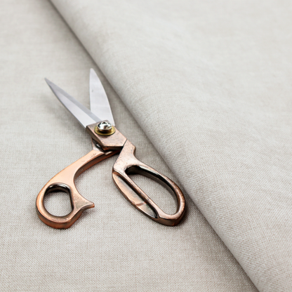 A textured, light beige woven upholstery fabric.