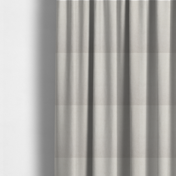 The fabric used to create these made-to-measure curtains is a textured, light beige woven upholstery fabric.