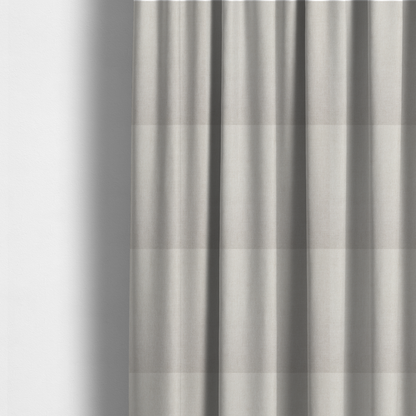 The fabric used to create these made-to-measure curtains is a textured, light beige woven upholstery fabric.