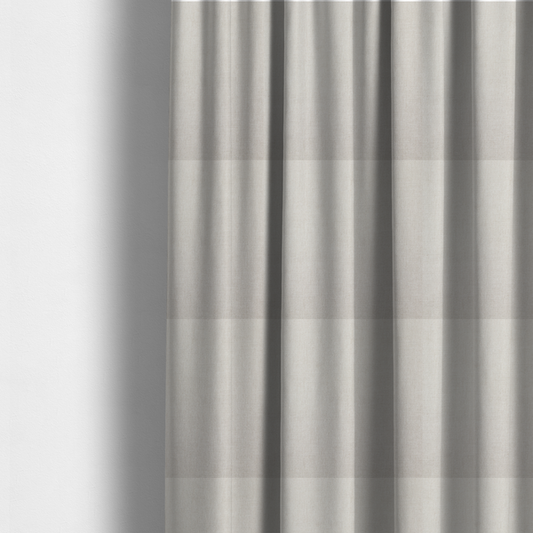 The fabric used to create these made-to-measure curtains is a textured, light beige woven upholstery fabric.