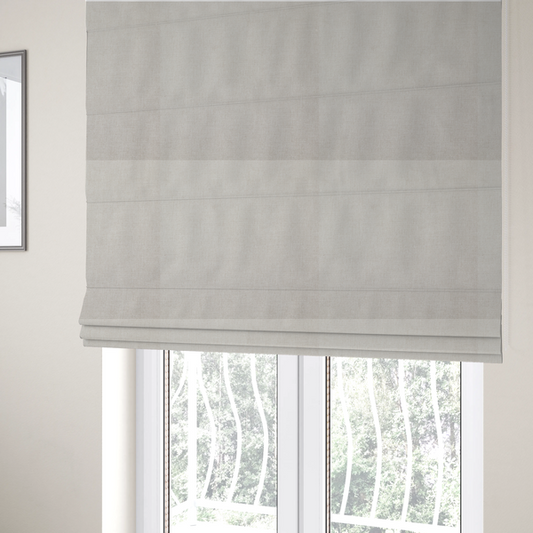 The fabric used to create these Roman blinds is a textured, light beige woven upholstery fabric.