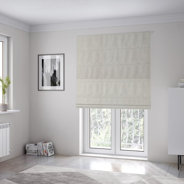 The fabric used to create these Roman blinds is a textured, light beige woven upholstery fabric.