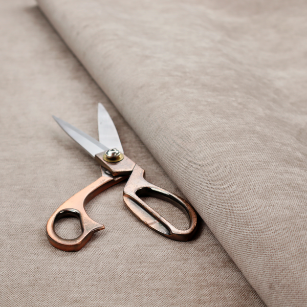 A textured, warm taupe or tan woven upholstery fabric.