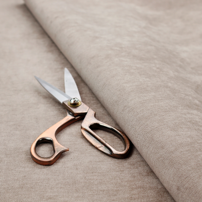 A textured, warm taupe or tan woven upholstery fabric.
