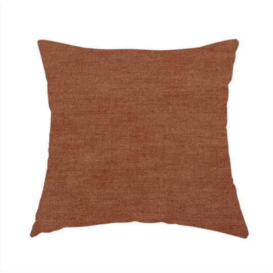 The fabric used to create this handmade cushion is a textured, rich rust or burnt orange woven upholstery fabric.