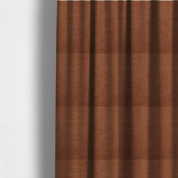 The fabric used to create these made-to-measure curtains is a textured, rich rust or burnt orange woven upholstery fabric.