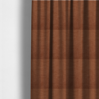 The fabric used to create these made-to-measure curtains is a textured, rich rust or burnt orange woven upholstery fabric.