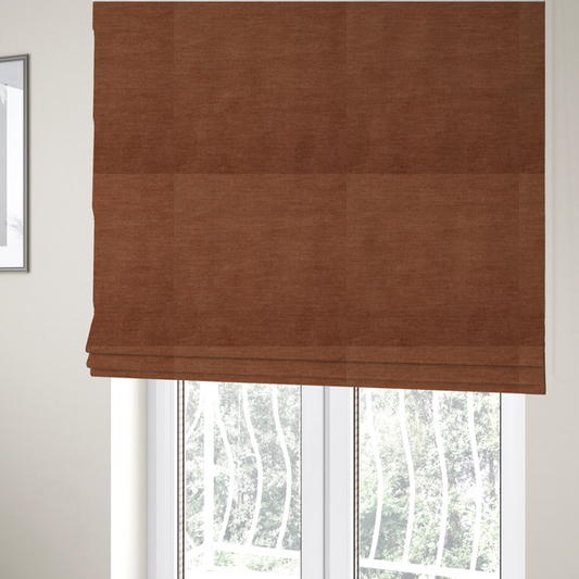The fabric used to create these Roman blinds is a textured, rich rust or burnt orange woven upholstery fabric.