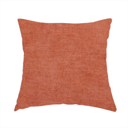 The fabric used to create this handmade cushion is a textured, vibrant burnt orange or coral-coloured woven upholstery fabric.