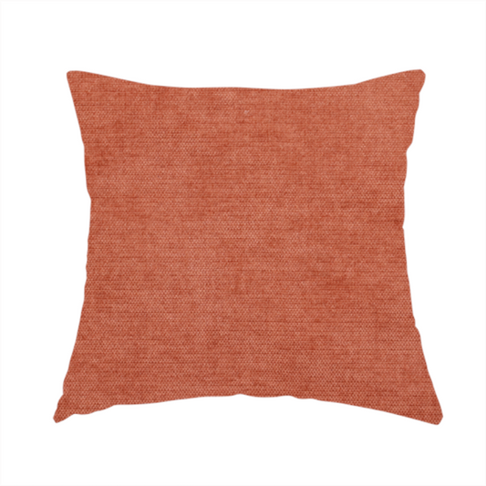 The fabric used to create this handmade cushion is a textured, vibrant burnt orange or coral-coloured woven upholstery fabric.