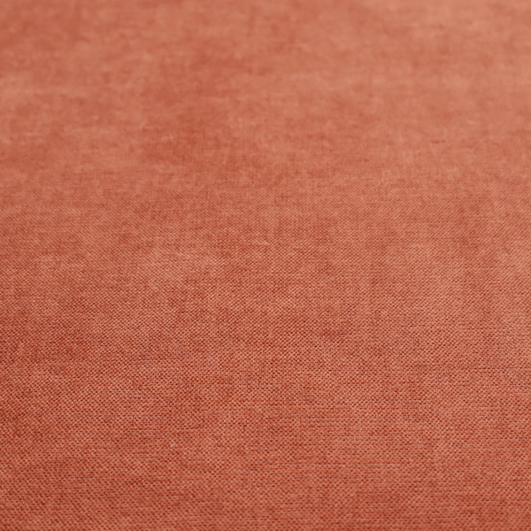 A textured, vibrant burnt orange or coral-coloured woven upholstery fabric.