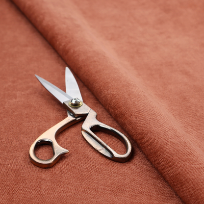 A textured, vibrant burnt orange or coral-coloured woven upholstery fabric.