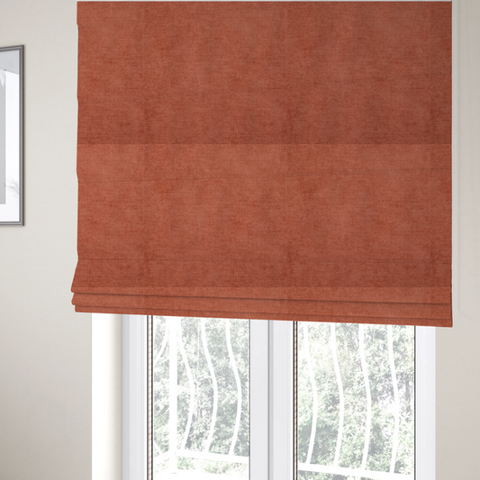 The fabric used to create these Roman blinds is a textured, vibrant burnt orange or coral-coloured woven upholstery fabric.