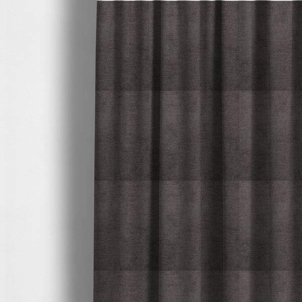 The fabric used to create these made-to-measure curtains is a textured, dark charcoal grey or brown-grey woven upholstery fabric.
