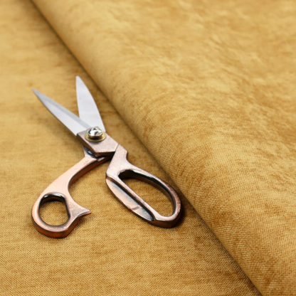 A textured, golden yellow or mustard woven upholstery fabric.
