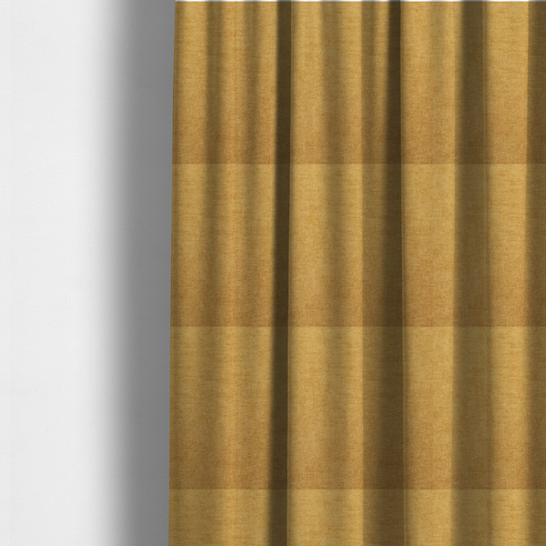 The fabric used to create these made-to-measure curtains is a  textured, golden yellow or mustard woven upholstery fabric.