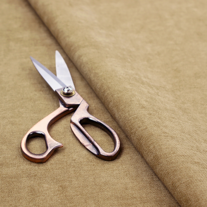 A textured, light brown or camel-coloured woven upholstery fabric.