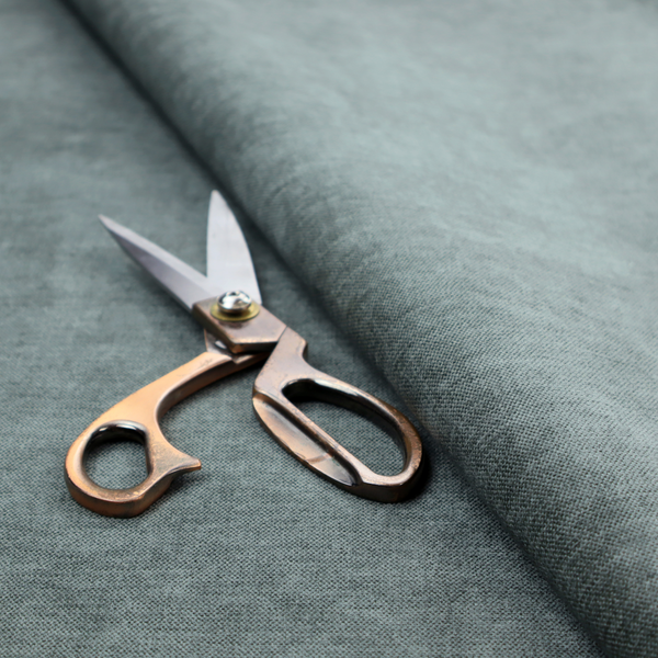 A textured, grey-blue or muted teal woven upholstery fabric.