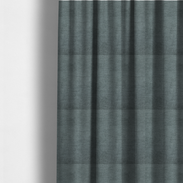 The fabric used to create these made-to-measure curtains is a textured, grey-blue or muted teal woven upholstery fabric.