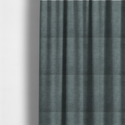 The fabric used to create these made-to-measure curtains is a textured, grey-blue or muted teal woven upholstery fabric.