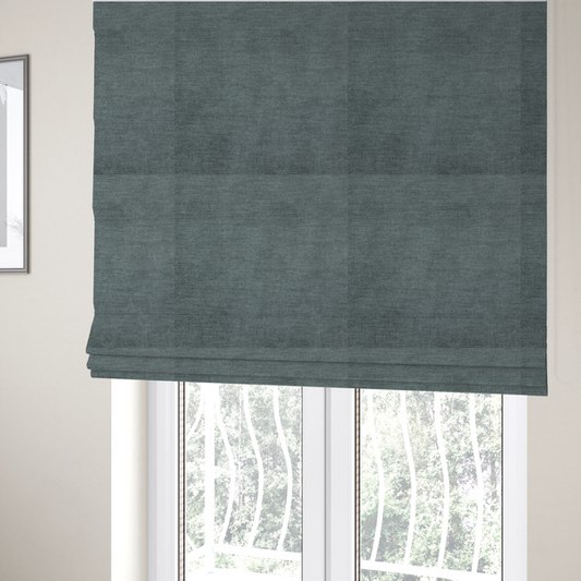 The fabric used to create these Roman blinds is a textured, grey-blue or muted teal woven upholstery fabric.