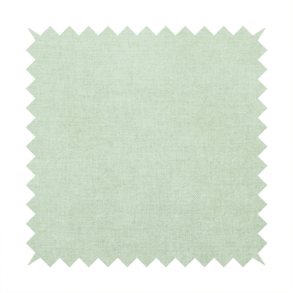 A textured, light mint green or pale sage green woven upholstery fabric.