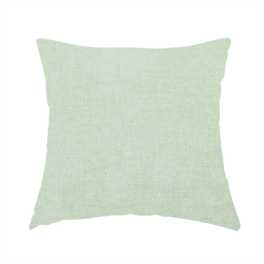 The fabric used to create this handmade cushion is a textured, light mint green or pale sage green woven upholstery fabric.