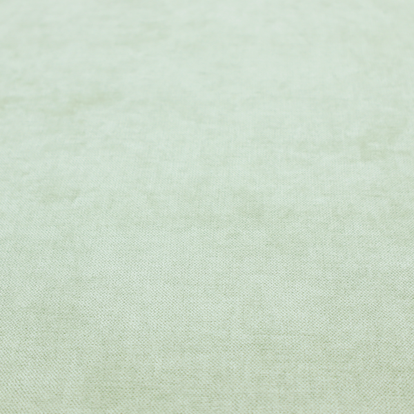 A textured, light mint green or pale sage green woven upholstery fabric.
