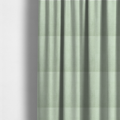 The fabric used to create these made-to-measure curtains is a textured, light mint green or pale sage green woven upholstery fabric.