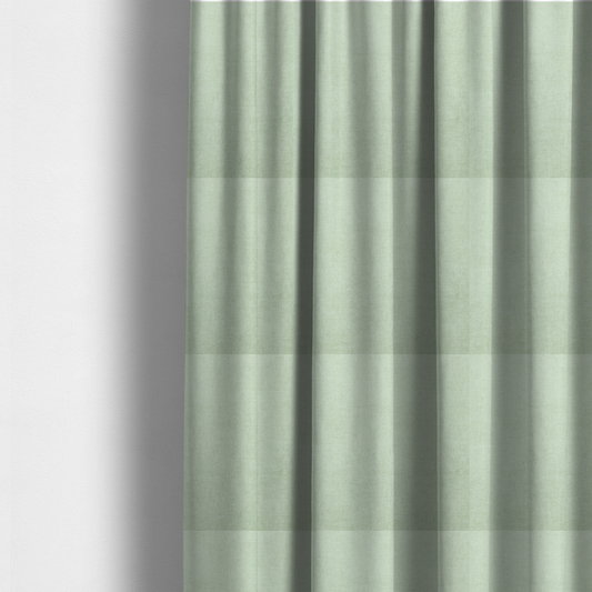 The fabric used to create these made-to-measure curtains is a textured, light mint green or pale sage green woven upholstery fabric.