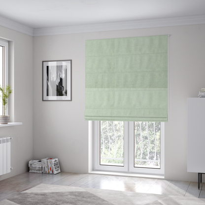 The fabric used to create these Roman blinds is a  textured, light mint green or pale sage green woven upholstery fabric.