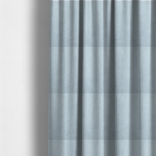 The fabric used to create these made-to-measure curtains is a textured, light blue or pale sky blue woven upholstery fabric.