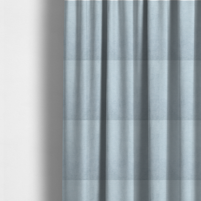 The fabric used to create these made-to-measure curtains is a textured, light blue or pale sky blue woven upholstery fabric.