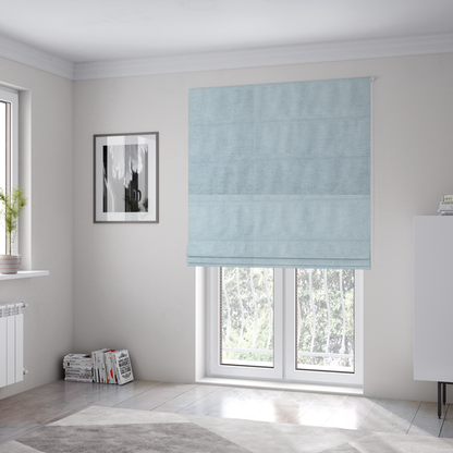 The fabric used to create these Roman blinds is a textured, light blue or pale sky blue woven upholstery fabric.