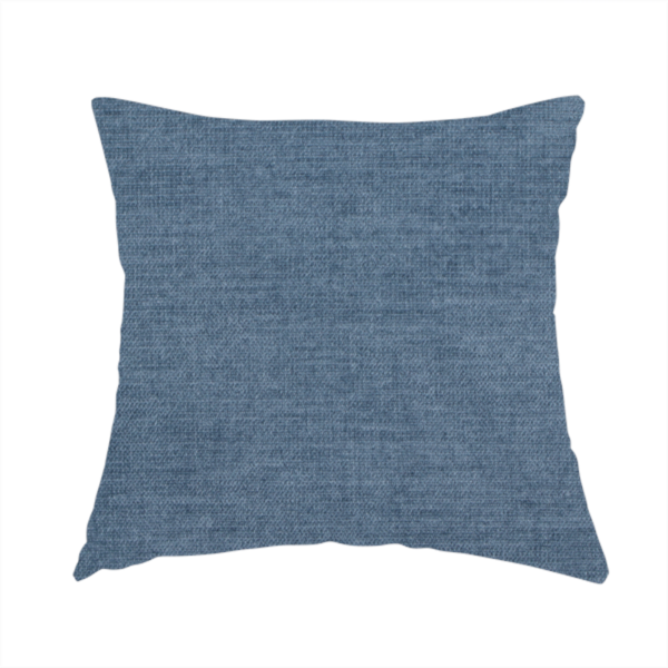 The fabric used to create this handmade cushion is a textured, denim blue or dusty blue woven upholstery fabric.