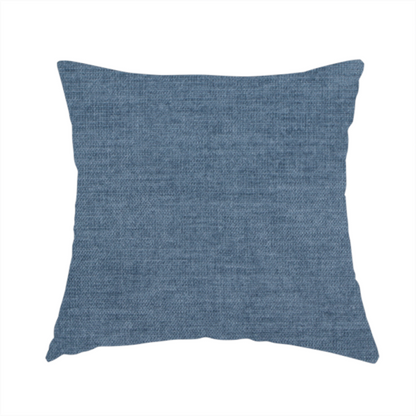 The fabric used to create this handmade cushion is a textured, denim blue or dusty blue woven upholstery fabric.