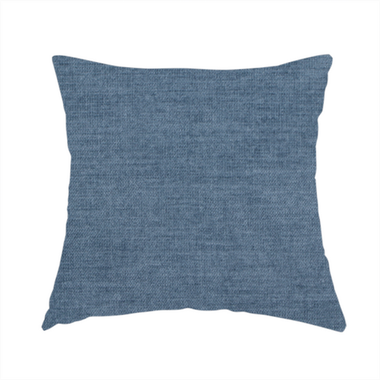 The fabric used to create this handmade cushion is a textured, denim blue or dusty blue woven upholstery fabric.