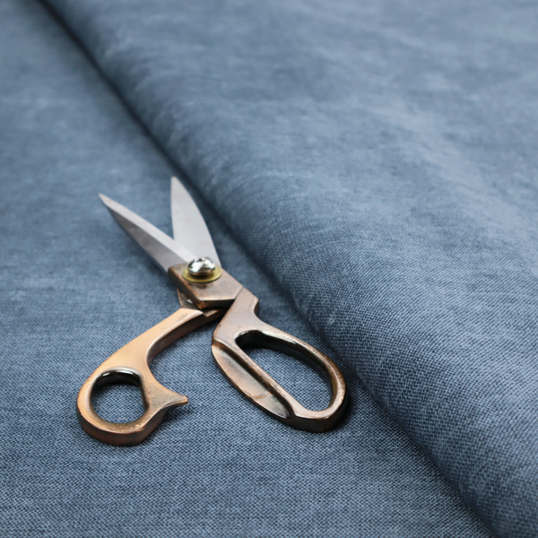 A textured, denim blue or dusty blue woven upholstery fabric.