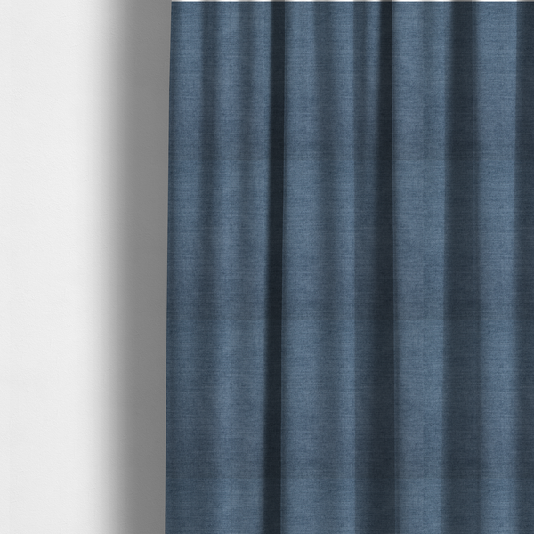 The fabric used to create these made-to-measure curtains is a textured, denim blue or dusty blue woven upholstery fabric.