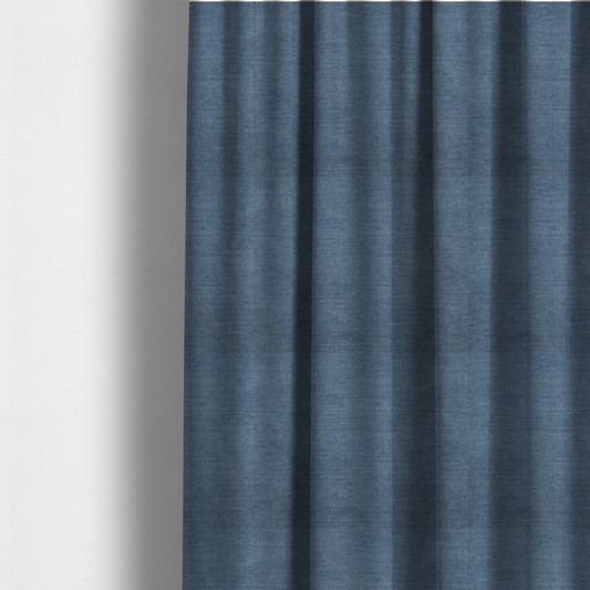 The fabric used to create these made-to-measure curtains is a textured, denim blue or dusty blue woven upholstery fabric.