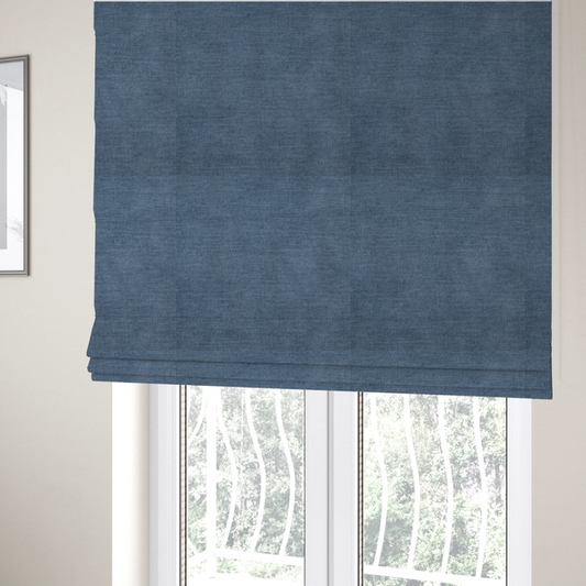 The fabric used to create these Roman blinds is a textured, denim blue or dusty blue woven upholstery fabric.