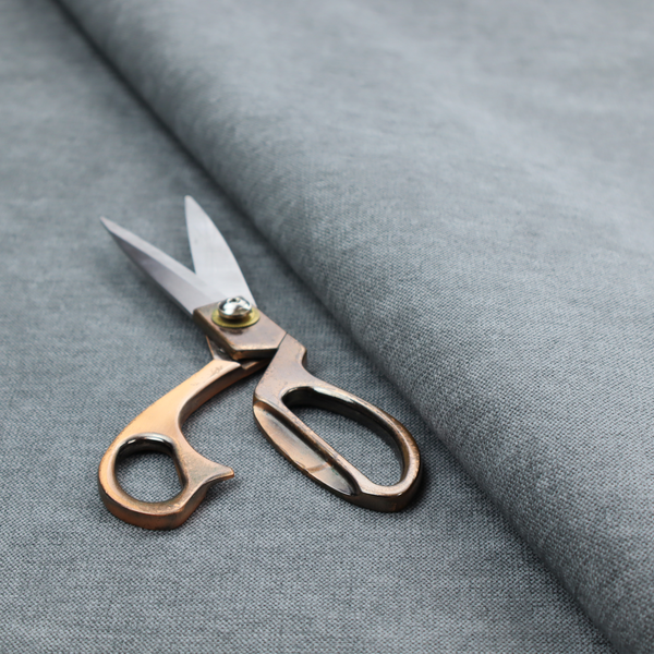 A textured, medium grey or steel grey woven upholstery fabric.