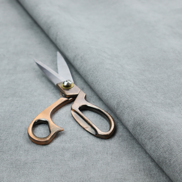 A textured, light grey or silver grey woven upholstery fabric.