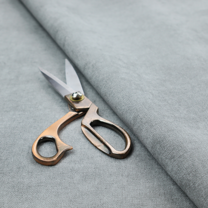 A textured, light grey or silver grey woven upholstery fabric.